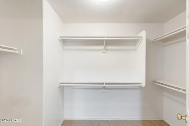 an empty room with chandelier fan