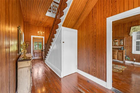a view of a hallway with wooden floor and stairs