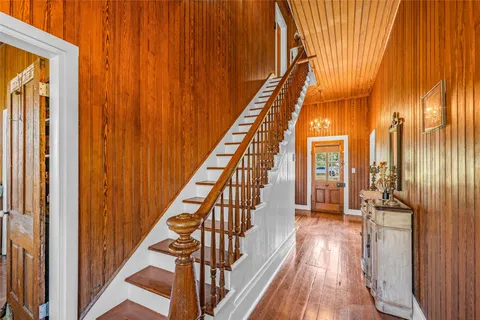 a view of a hallway with wooden floor and staircase