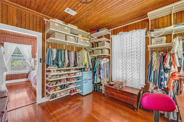 a view of walk in closet with clothes and shoes