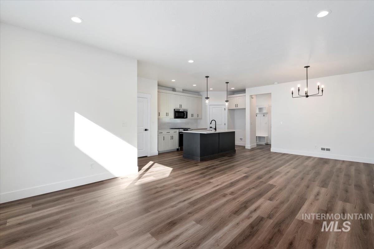 752 South Calhoun Lane Star, ID 83669 - Photo 4 of 45 Open-concept living area featuring wood-finish flooring, recessed lighting, and a modern chandelier