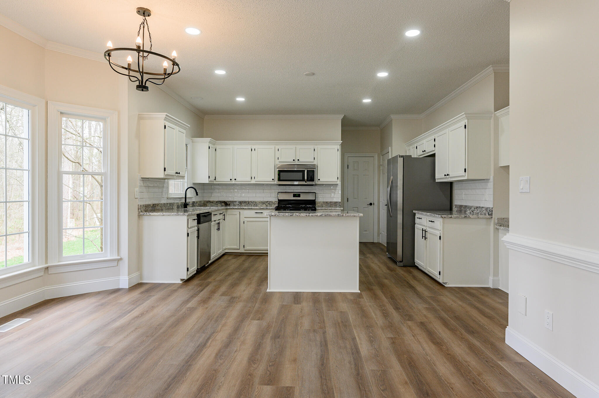 5620 Raddington Street Raleigh, NC 27613 - Photo 7 of 41 a kitchen with stainless steel appliances granite countertop a refrigerator a stove top oven a sink dishwasher and white cabinets with wooden floor