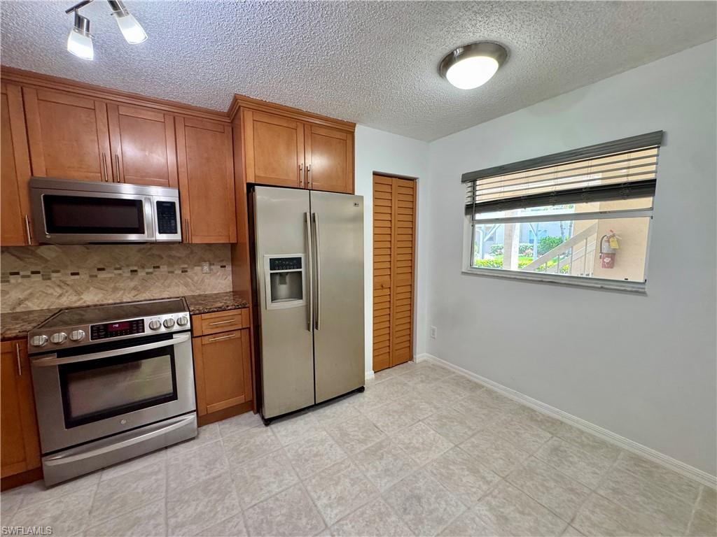 661 Squire Circle, Unit 101 Naples, FL 34104 - Photo 25 of 25 a view of a kitchen with a stove cabinets and stainless steel appliances
