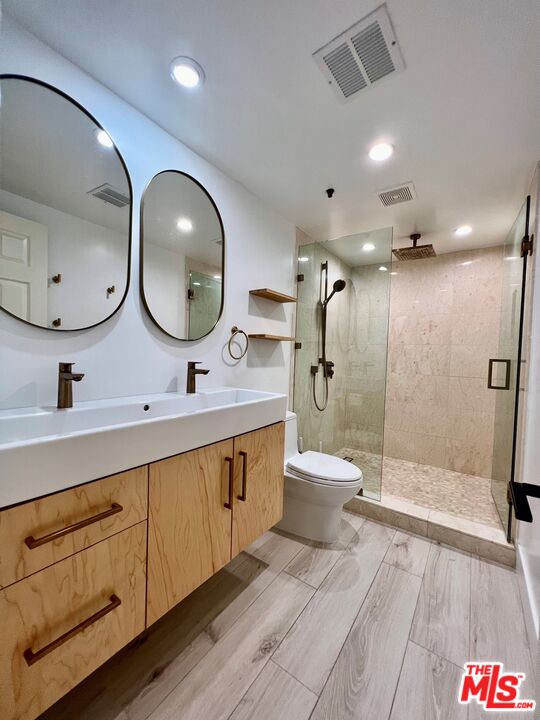 1128 17th Street, Unit E Santa Monica, CA 90403 - Photo 11 of 25 a spacious bathroom with a double vanity sink a large mirror a toilet and a shower