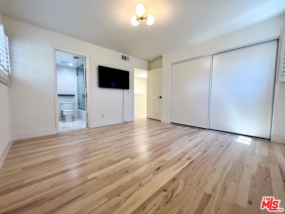 1128 17th Street, Unit E Santa Monica, CA 90403 - Photo 12 of 25 a view of an empty room with wooden floor and a window