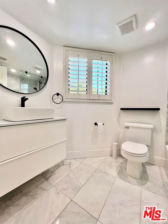 1128 17th Street, Unit E Santa Monica, CA 90403 - Photo 14 of 25 a bathroom with a toilet a sink and a mirror