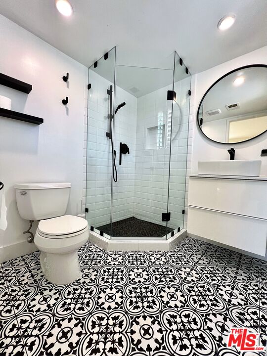 1128 17th Street, Unit E Santa Monica, CA 90403 - Photo 18 of 25 a bathroom with a toilet a mirror and shower