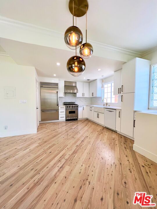 1128 17th Street, Unit E Santa Monica, CA 90403 - Photo 4 of 25 a kitchen with stainless steel appliances granite countertop a stove and a wooden floors
