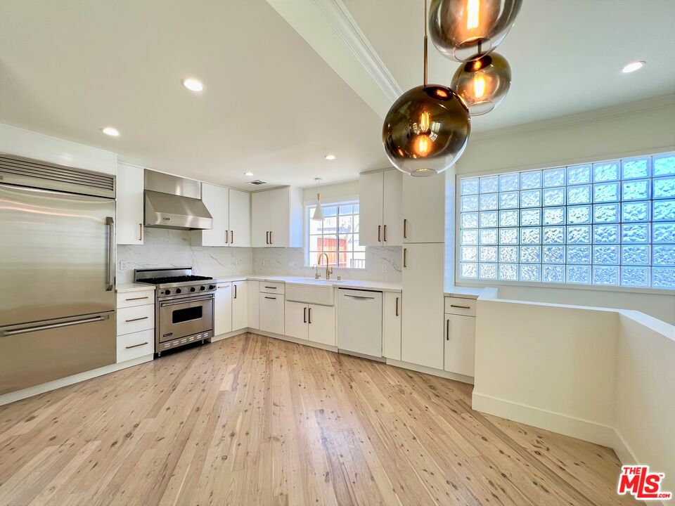 1128 17th Street, Unit E Santa Monica, CA 90403 - Photo 5 of 25 a kitchen with stainless steel appliances granite countertop a stove and a refrigerator