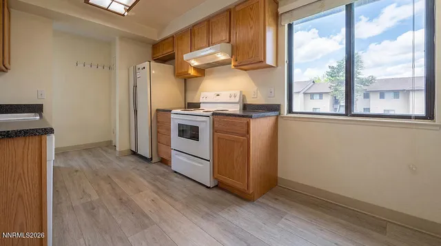 a kitchen with granite countertop a stove and a refrigerator