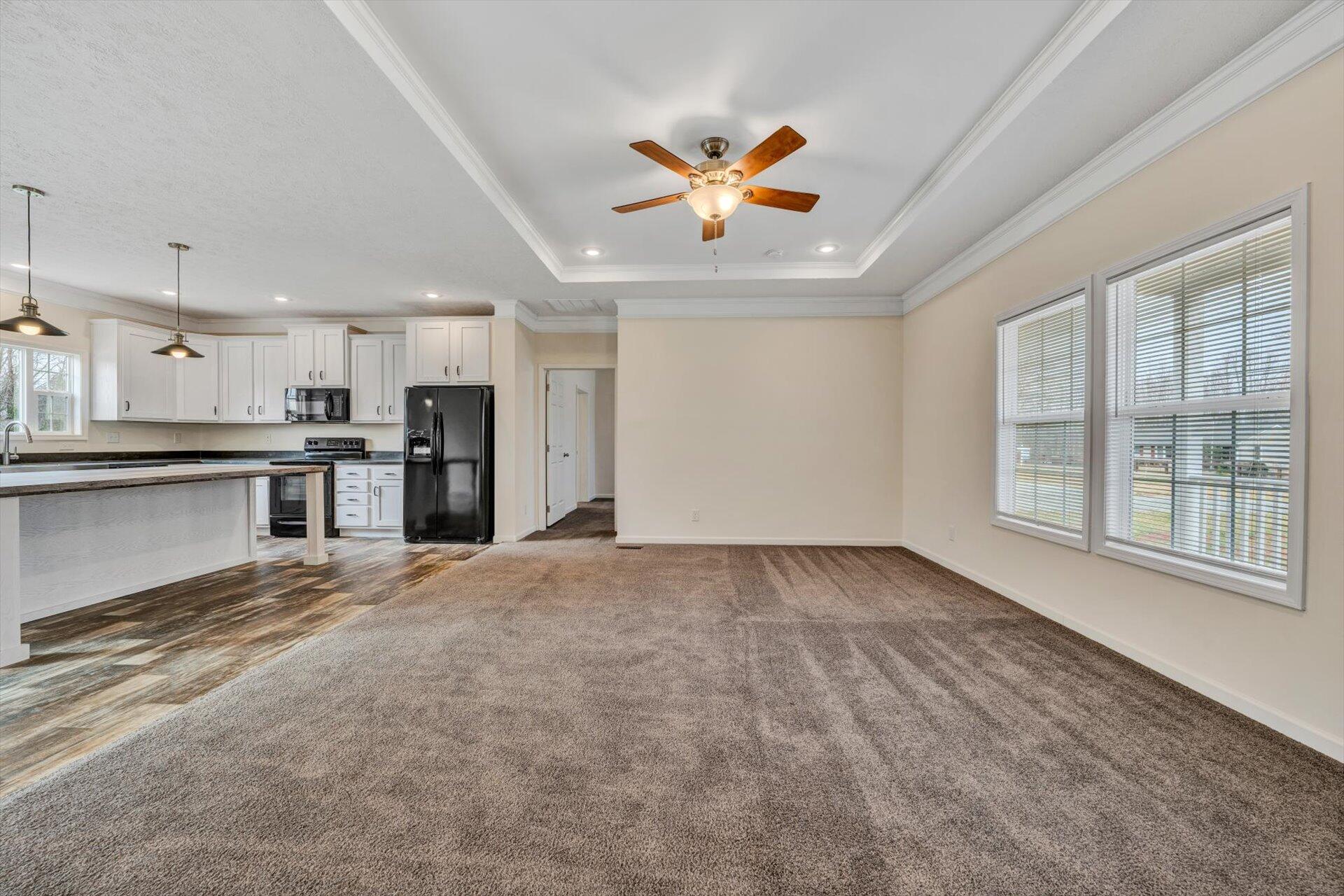 4993 Horseshoe Bend Road Goodview, VA 24095 - Photo 6 of 30 a view of a kitchen with a stove cabinets a ceiling fan and wooden floor
