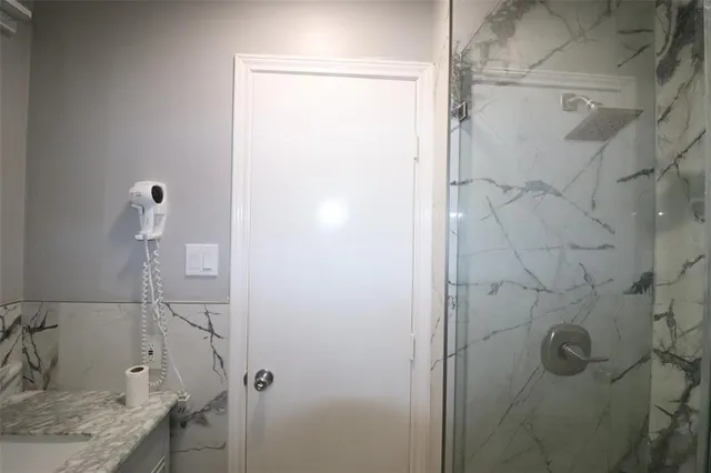a bathroom with a granite countertop shower and a sink