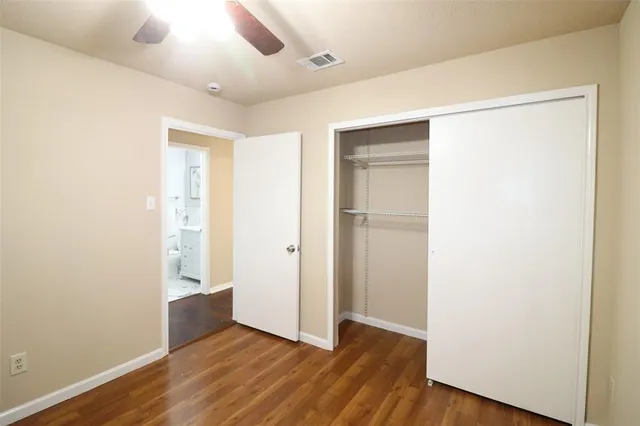 an empty room with wooden floor and closet