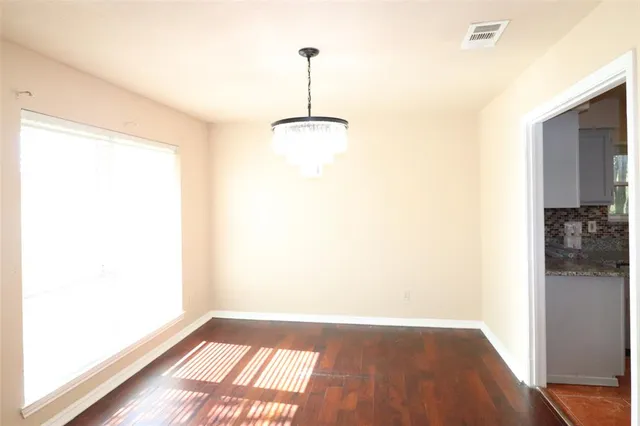 a view of a room with wooden floor and a window