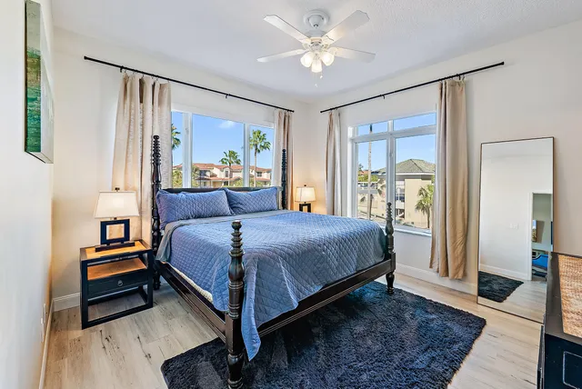 a bedroom with a bed wooden floor and a window