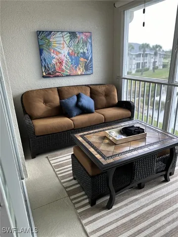 a living room with furniture a rug and a window