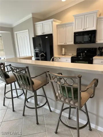 a kitchen with a stove a sink and white cabinets