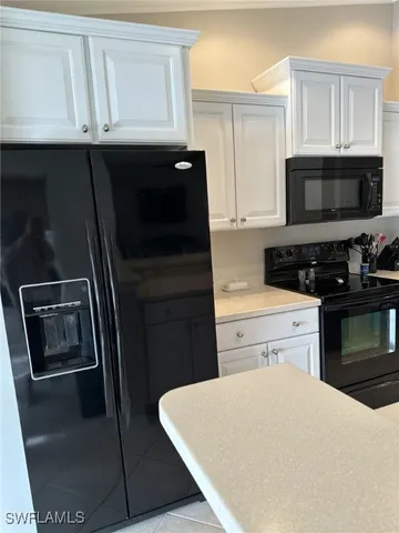 a kitchen with granite countertop a refrigerator stove and microwave