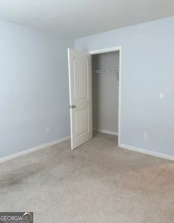 a view of an empty room and closet area