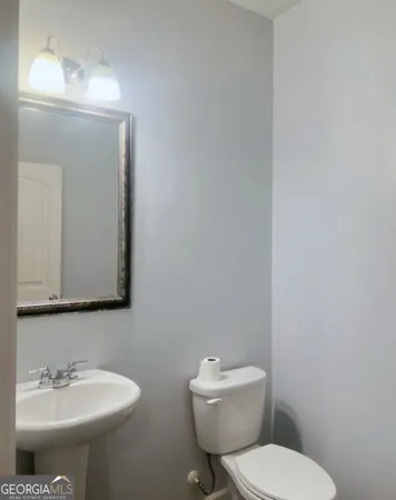a bathroom with a toilet a sink and mirror