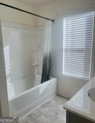 a bathroom with a bathtub and shower
