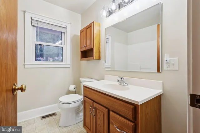 a bathroom with a sink toilet and mirror
