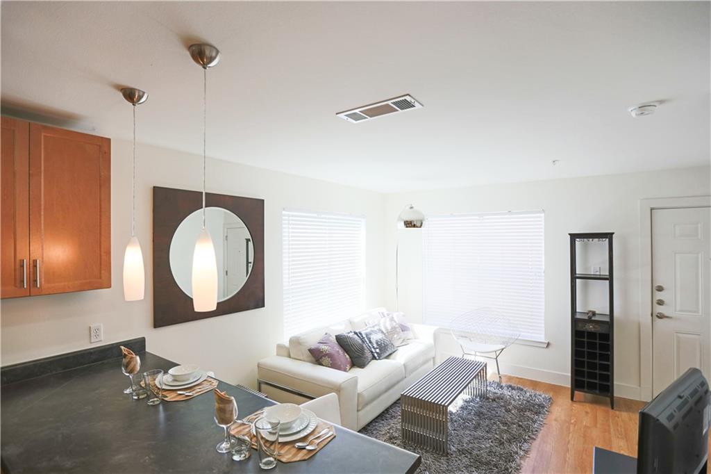 711 West 32nd Street, Unit 115 Austin, TX 78705 - Photo 5 of 23 a living room with furniture and a mirror