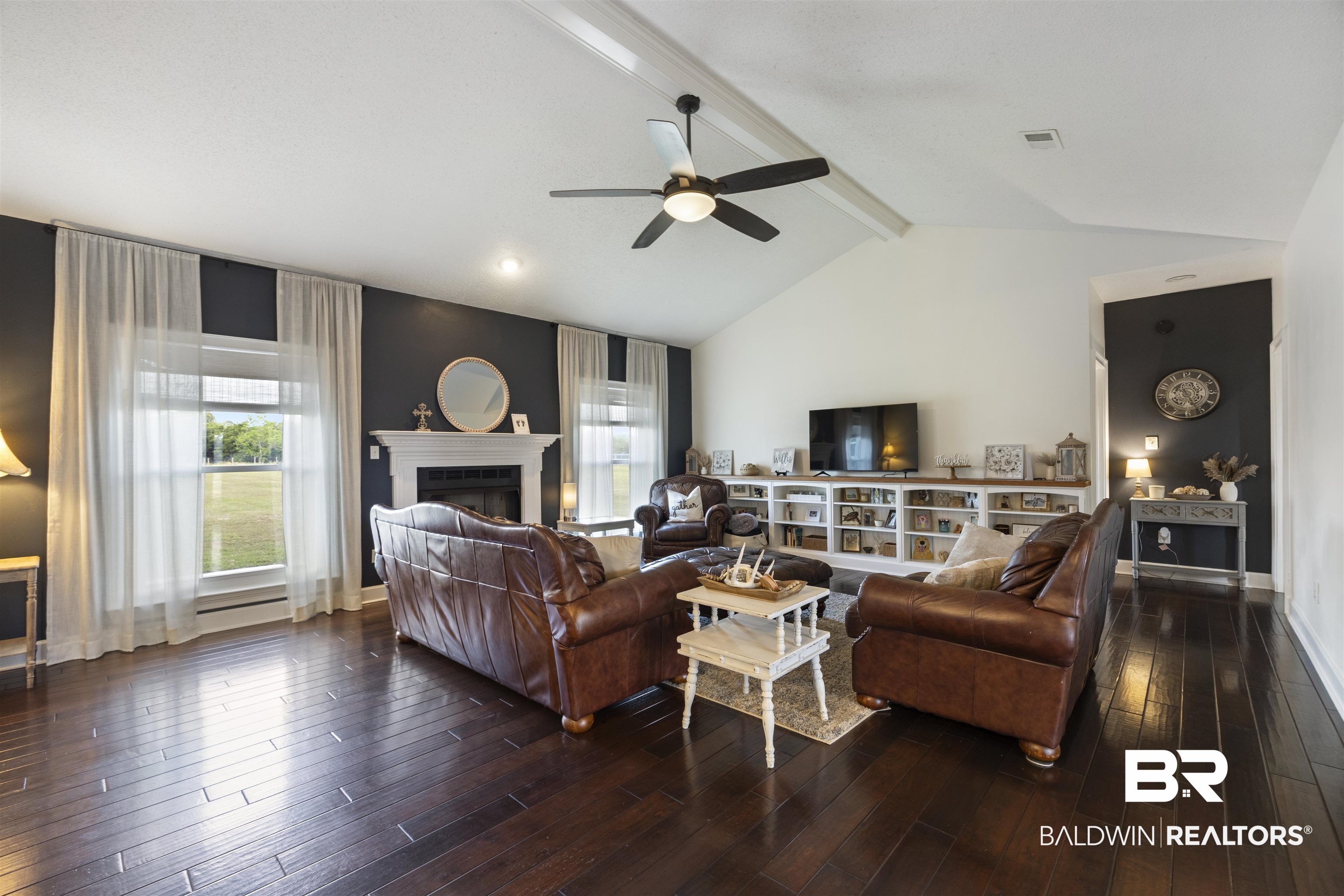 9855 Stucki Road Elberta, AL 36530 - Photo 14 of 54 Living area featuring dark wood finished floors, a fireplace, a ceiling fan, and beamed ceiling