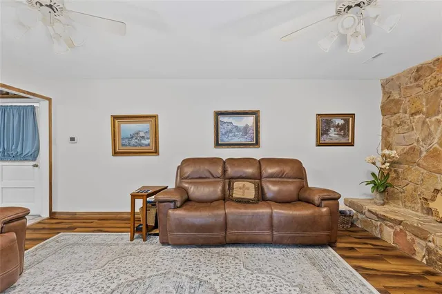 a living room with furniture a couch and paintings on the wall