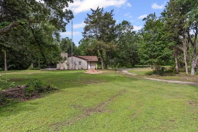 a view of a swimming pool with lawn chairs under an umbrella