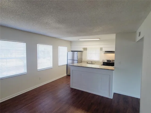 a kitchen with granite countertop a stove and wooden floor
