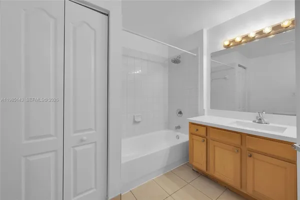 a bathroom with a tub sink vanity and mirror