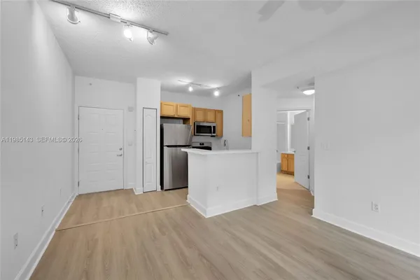 a view of a kitchen with a sink and a refrigerator
