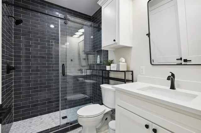 a bathroom with a sink a toilet and shower