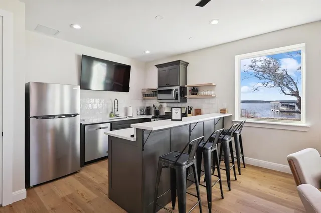 a kitchen with a refrigerator a stove a microwave a dining table and chairs