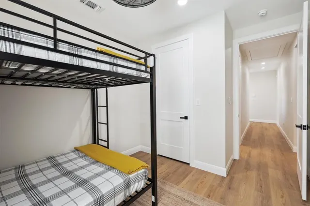 a bedroom with a bed and wooden floor