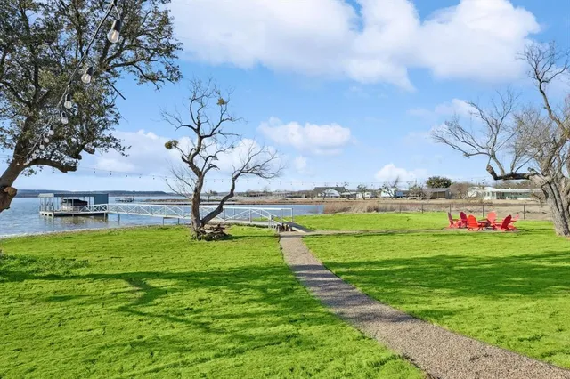 a view of a big yard with potted plants and large trees
