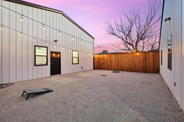a view of a house with backyard and parking