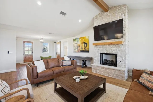a living room with furniture a flat screen tv and a fireplace