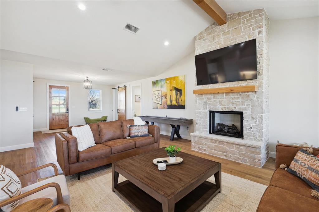 413 Hoot Avenue Graford, TX 76449 - Photo 6 of 38 a living room with furniture a flat screen tv and a fireplace