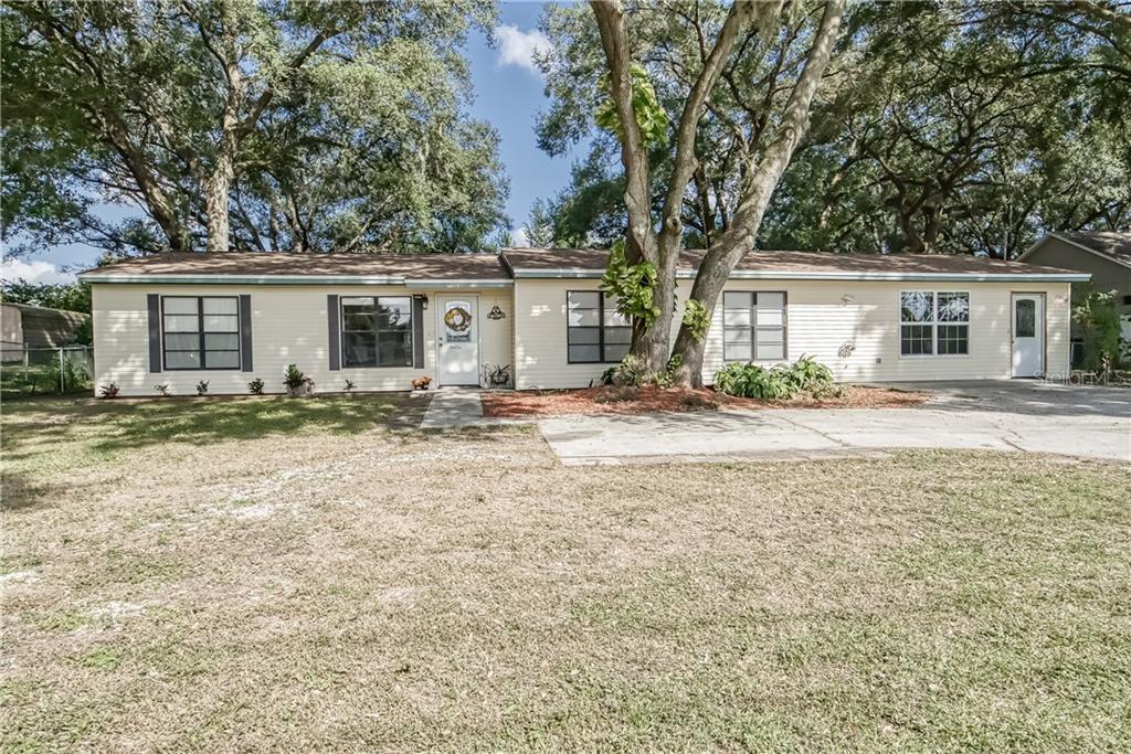 6998 Fort King Road Zephyrhills, FL 33541 - Photo 1 of 1 a house with trees in the background