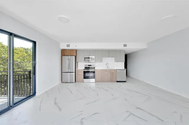 a kitchen with stainless steel appliances a sink and a large window