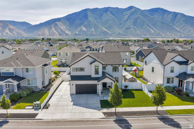 252 North Sunrise Rnch Drive Mapleton, UT 84664 - Photo 55 of 62 Modern farmhouse-style home featuring a two-car garage, manicured front lawn, and a light-toned exterior with dark trim