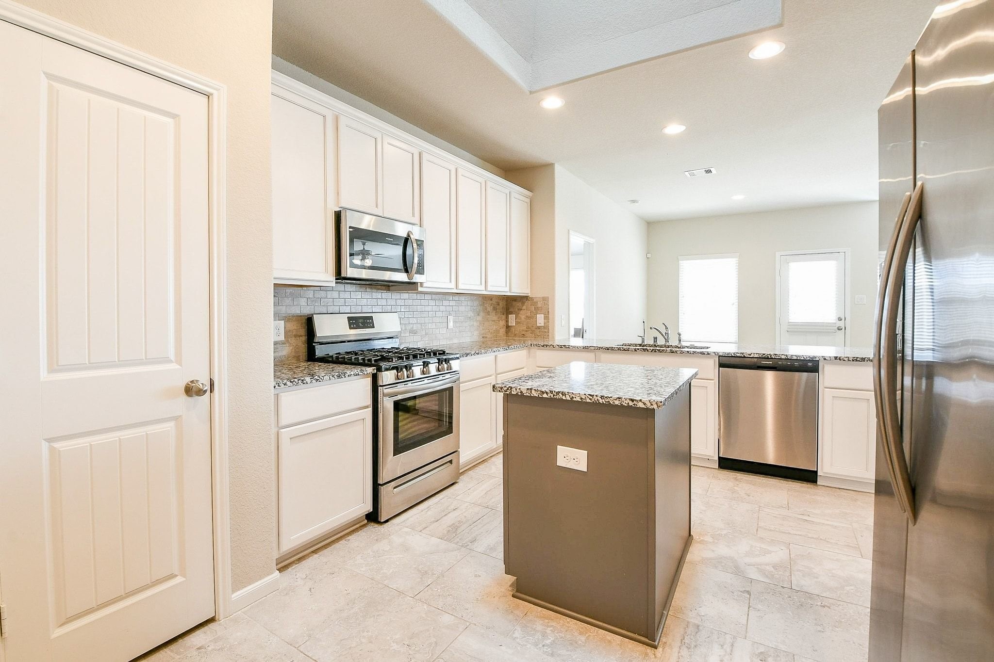 1515 Anyder Place Houston, TX 77047 - Photo 7 of 21 a kitchen with stainless steel appliances granite countertop a stove a sink and a refrigerator