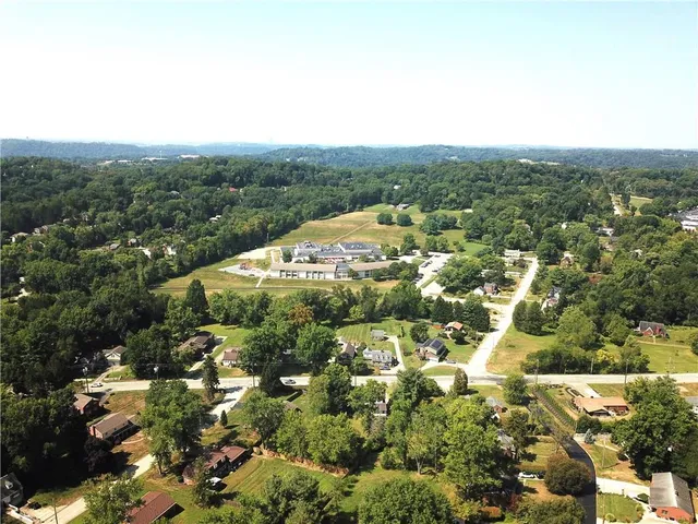 an aerial view of residential houses with outdoor space and trees