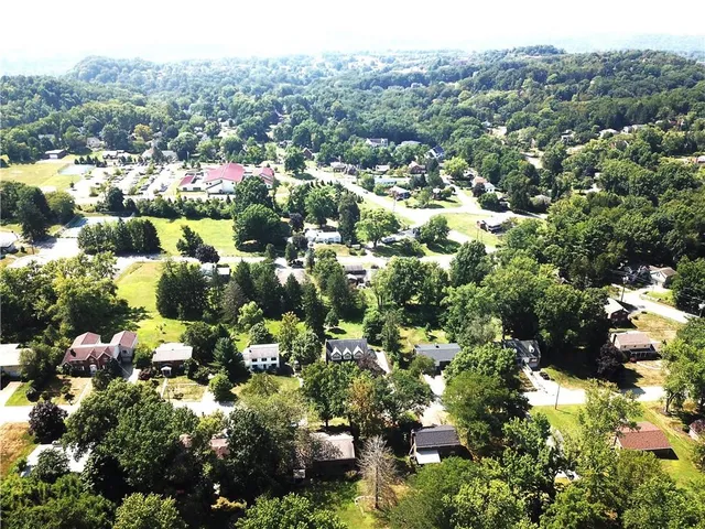 an aerial view of house with yard and mountain view in back