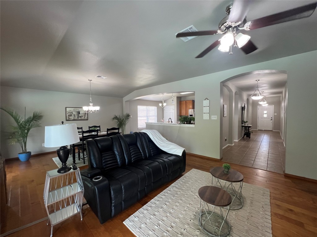 404 Patton Cove Bastrop, TX 78602 - Photo 17 of 40 Living area featuring wood finished floors, ceiling fan with notable chandelier, arched walkways