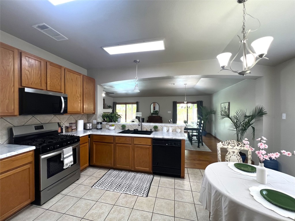 404 Patton Cove Bastrop, TX 78602 - Photo 18 of 40 Kitchen with a new sink, stainless steel appliances, light countertops, a peninsula