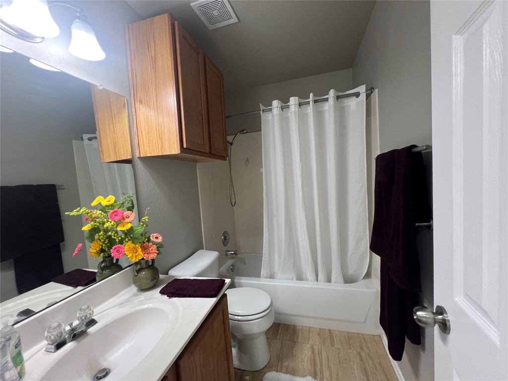 404 Patton Cove Bastrop, TX 78602 - Photo 34 of 40 Bathroom with shower / bath combo, vanity, and toilet