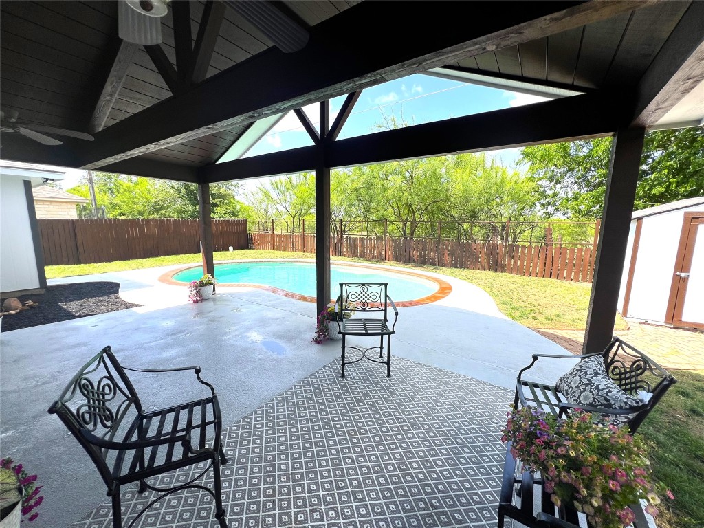 404 Patton Cove Bastrop, TX 78602 - Photo 4 of 40 View of swimming pool featuring a fenced in pool, a fenced backyard, a patio area, ceiling fan, and a shed